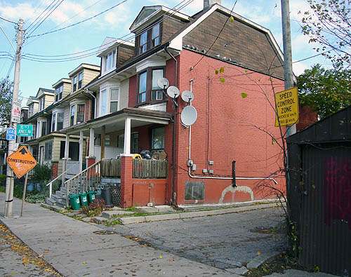 Driveway alongside row houses has small sign reading TO Nº 7 JONES AVE. →