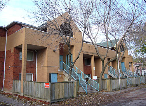 Brick row houses with inset entrances, some with gabled porticos