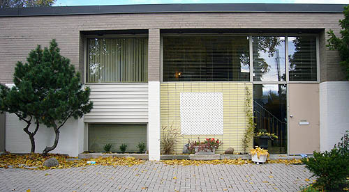 Two-storey building uses flat panes of glass, brown brick with a yellow-brick insert, and rectangular insets