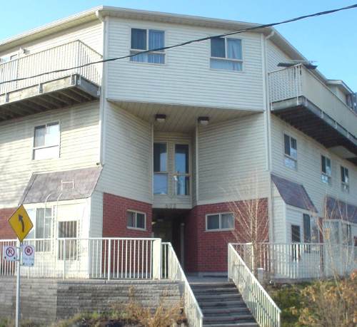 Two-storey corner entryway is inset at sharp angles from the adjoining walls