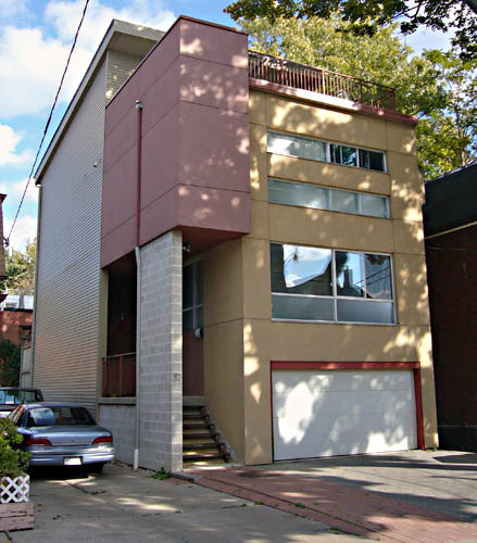 Modular house in grey brick, ochresiding, and burgundy stucco